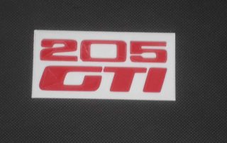 Logo de la peugeot 205 GTI imprimé en 3D en rouge sur fond blanc